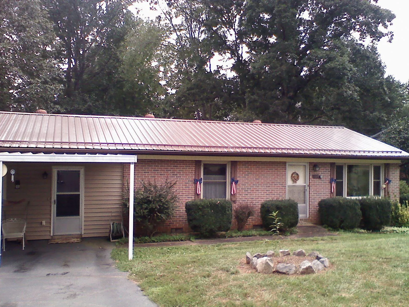 Bronze metal roof and carport on a brick ranch home — Roof Repair work by our crew in Bellona